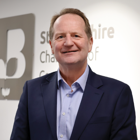 ceo in suit in front of corporate sign